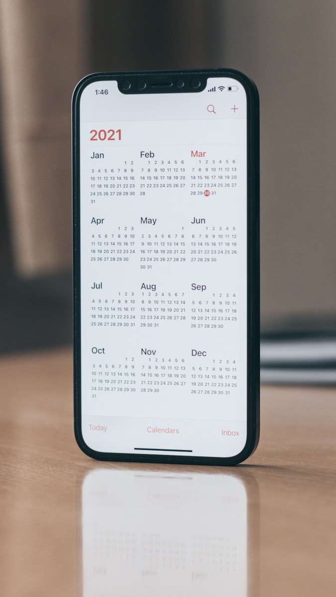 black android smartphone on brown wooden table, scheduling