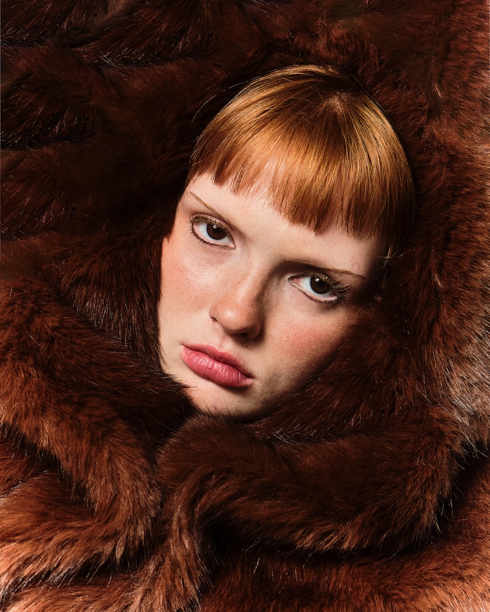 A woman with red hair wearing a fur coat instagram